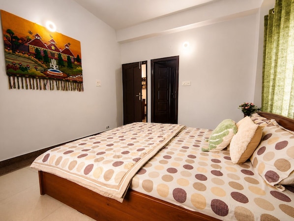 A bedroom with a bed, a painting, and a door.