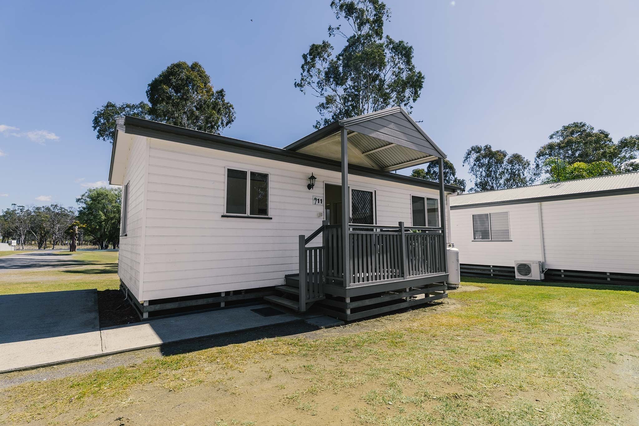 A small, single-story mobile home with a porch and a covered entryway.