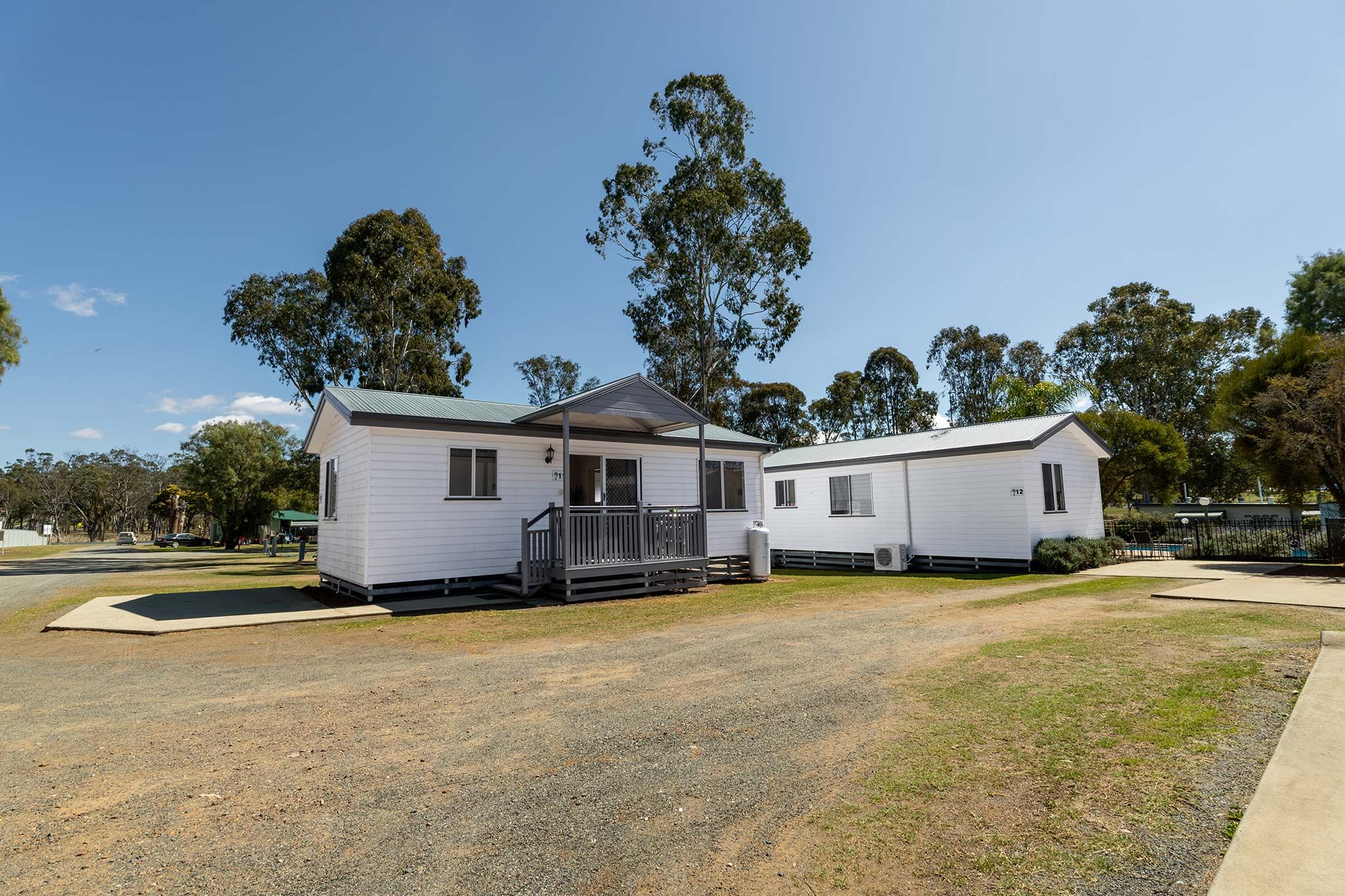 A two-story mobile home with a front porch and a small attached garage.