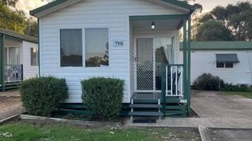A small, single-story house with a green door and a number '716' on the front.