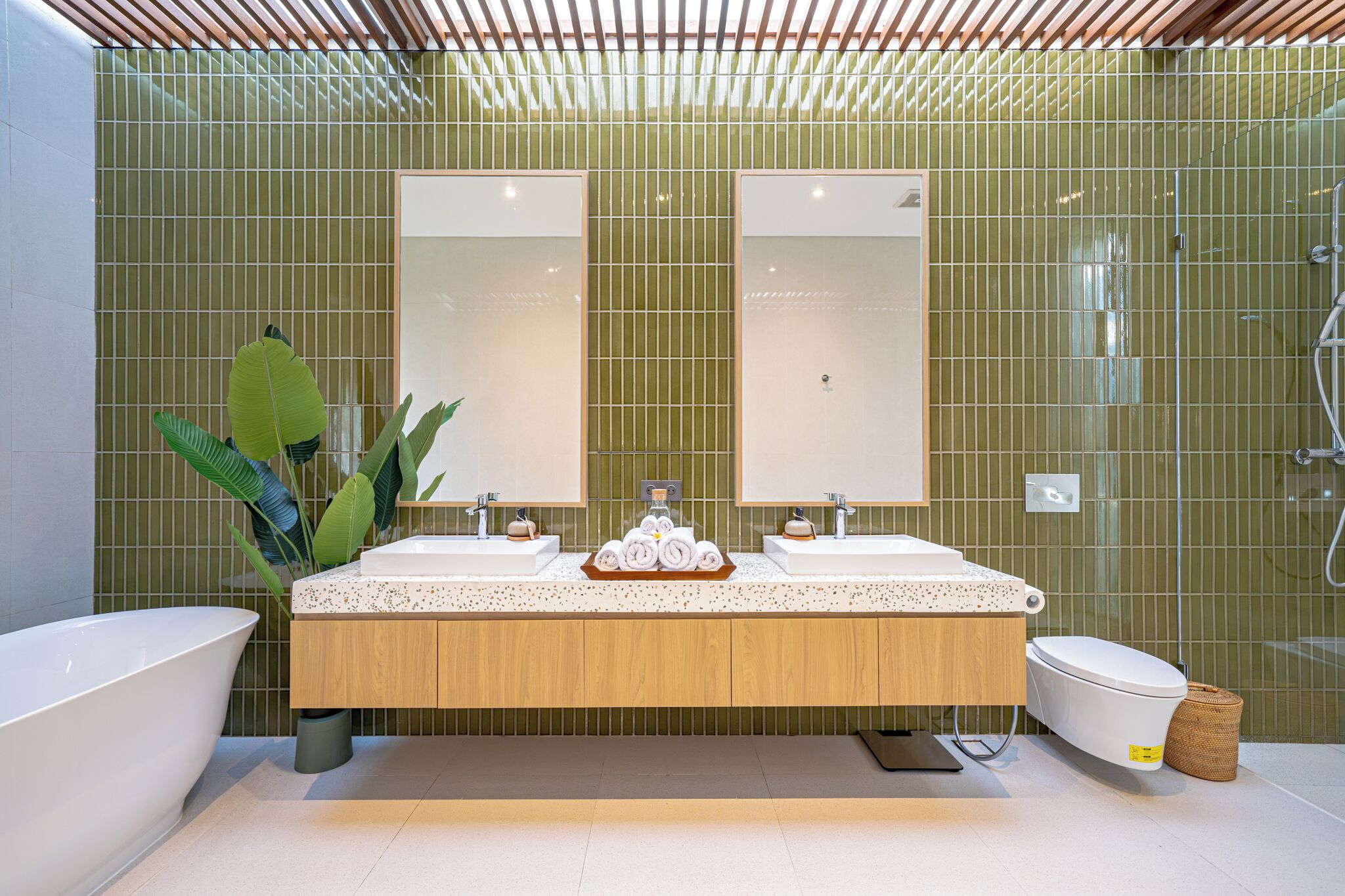 Une salle de bain moderne avec une baignoire sur pieds, un espace douche et un meuble-lavabo doté de deux miroirs.