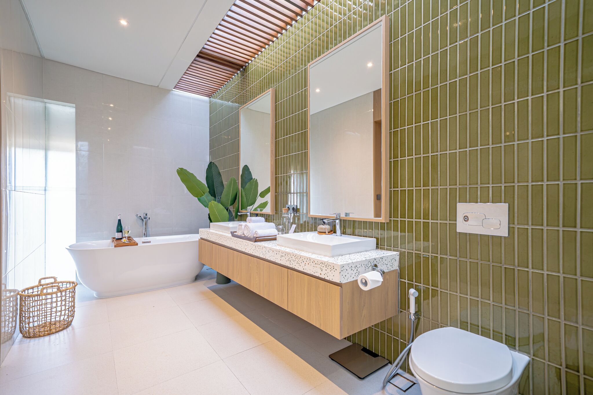 A modern bathroom with a freestanding bathtub, a wooden vanity, and a large mirror.