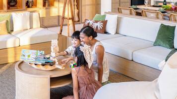 Una sala de estar moderna con un sofá, una mesa de centro y un niño jugando con un rompecabezas.
