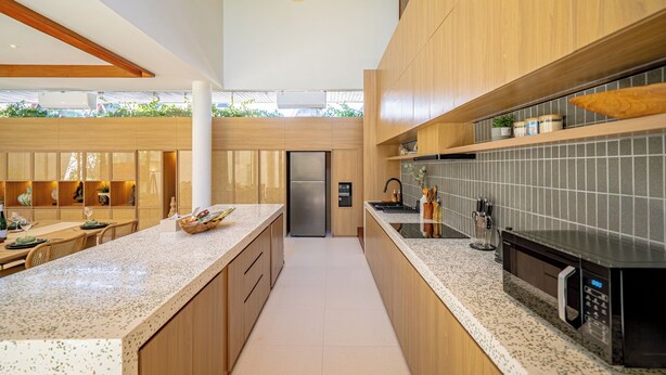 A modern kitchen with wooden cabinets, a stainless steel refrigerator, and a built-in microwave. - Villa Anaka Pererenan (Pererenan)