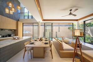 Una cocina moderna con comedor, ventanas amplias y ventilador de techo.