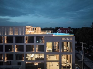 A hotel with multiple floors, large windows, and a rooftop area. - HOLM HOTEL CHIANGMAI (Chiang Mai)