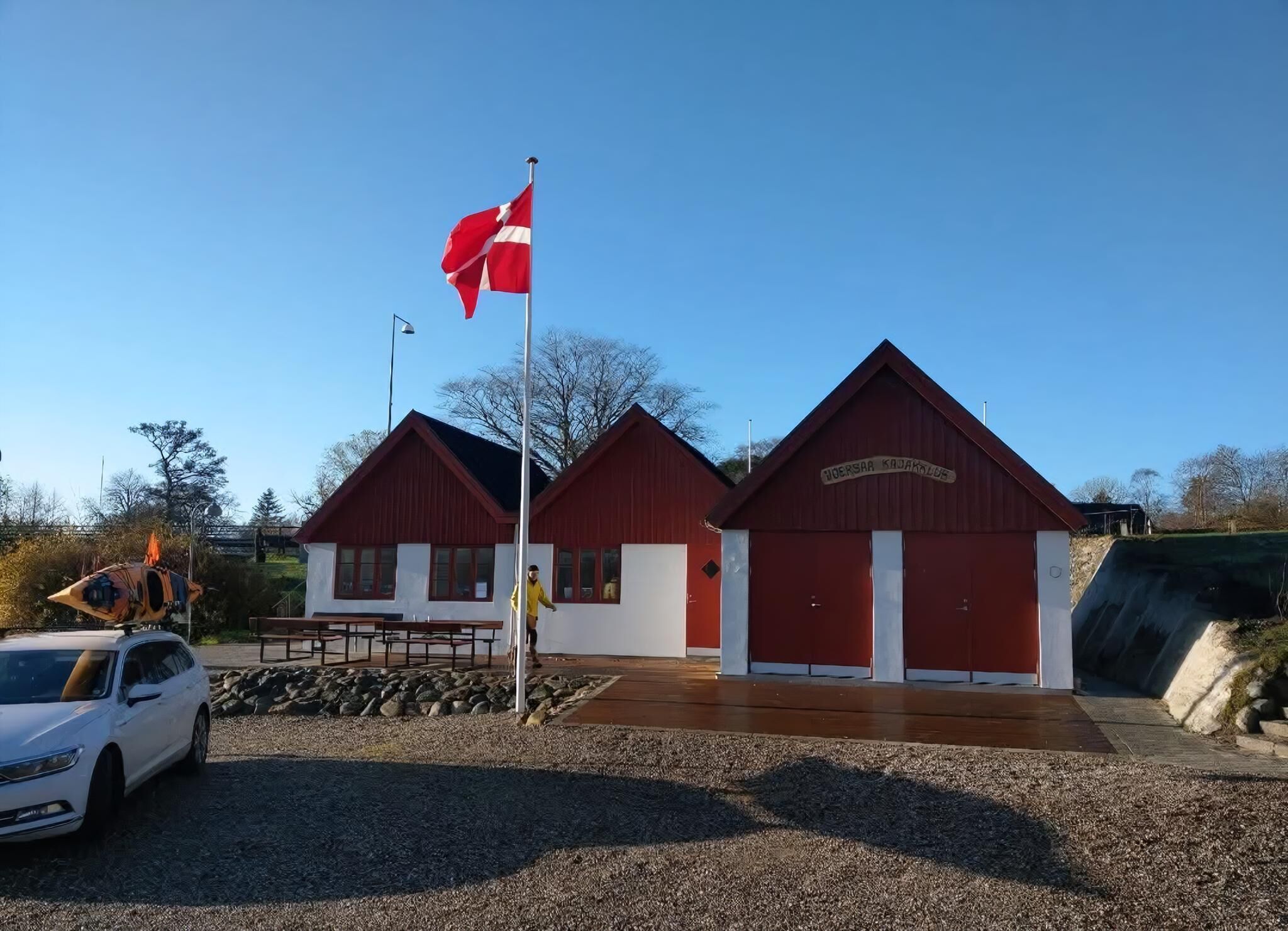 A building with a red roof and a flagpole with a flag.