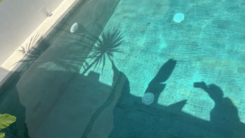 Une piscine aux eaux claires, bordée de carreaux et dotée d’une grille de vidange.