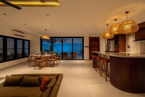 A modern interior with a dining area, kitchen, and seating space.