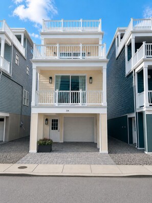 Ein zweigeschossiges Wohngebäude mit einer Garage im Vordergrund und einem Balkon im Obergeschoss, mit der Hausnummer 314 über der Garage.