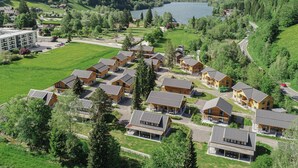 A resort with multiple wooden cabins, a central building, and a lake in the background. - Modern apartment with Alps and lake views (Afritz am See)