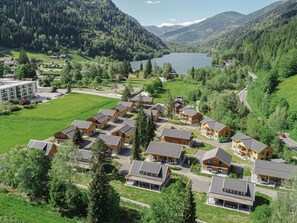 A resort with multiple wooden cabins, a central building, and a lake in the background. - Modern apartment with Alps and lake views (Afritz am See)