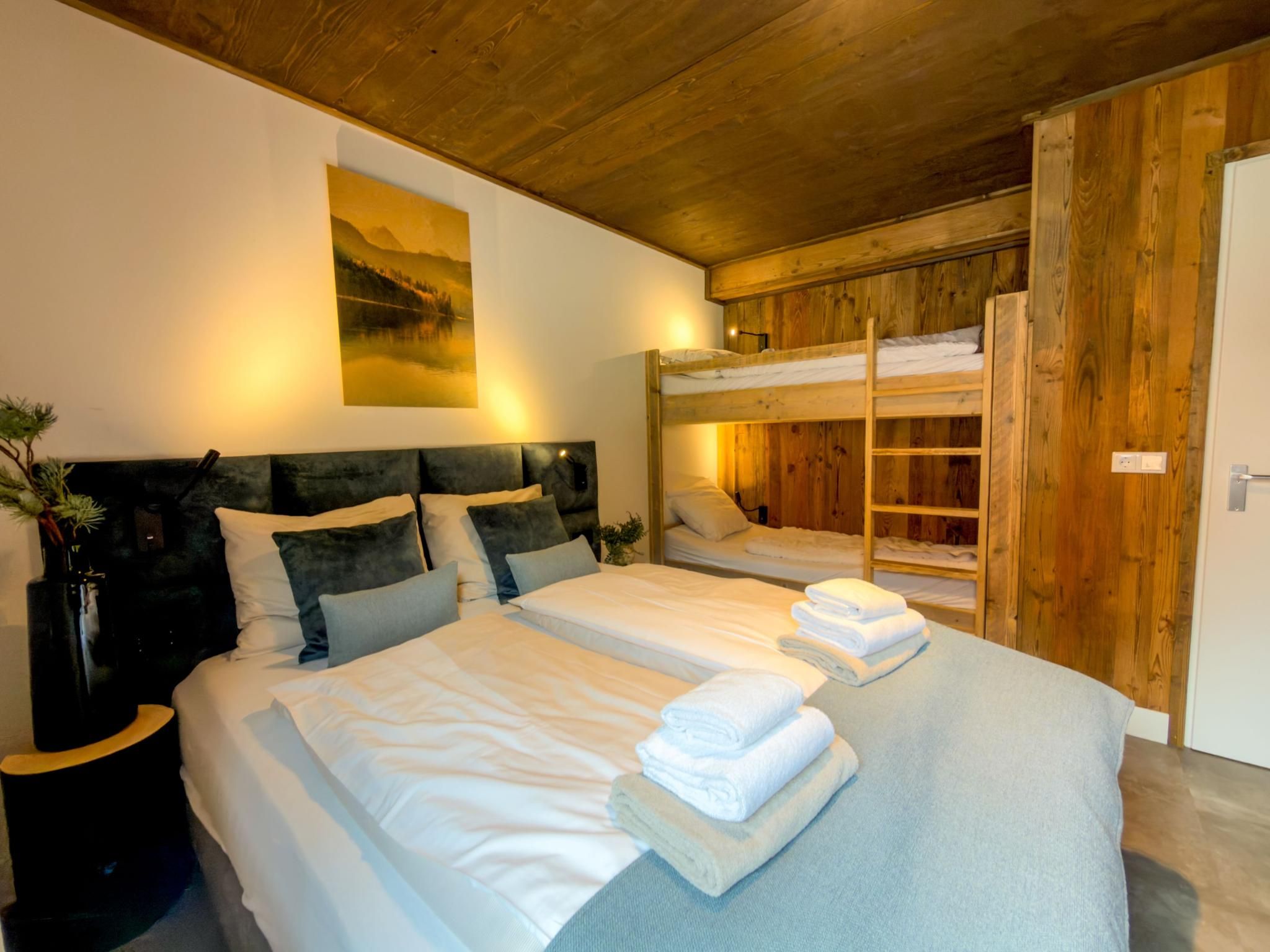 Un lit double avec une tête de lit, une table de chevet et une lampe fixée au mur.