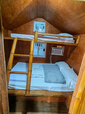Un letto a castello con scala, una finestra e un condizionatore d'aria in una stanza in legno.