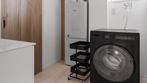 Un cuarto de lavado con lavadora de carga frontal, una puerta de madera, una pared blanca y una ventana.