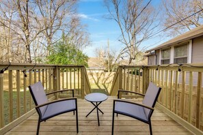 A wooden deck with two chairs and a small table, surrounded by a wooden fence. - The Scandic - Modern Group Stay/Fully Fenced Yard (Birmingham)