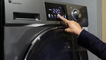 Una mano interactuando con el panel de control de una lavadora.