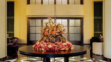 Una mesa redonda con un centro de mesa floral en el vestíbulo de un hotel.
