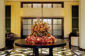 A round table with a floral centerpiece in a hotel lobby. - Mehood Elegant Intl. Nanhai Guangfo (Foshan)