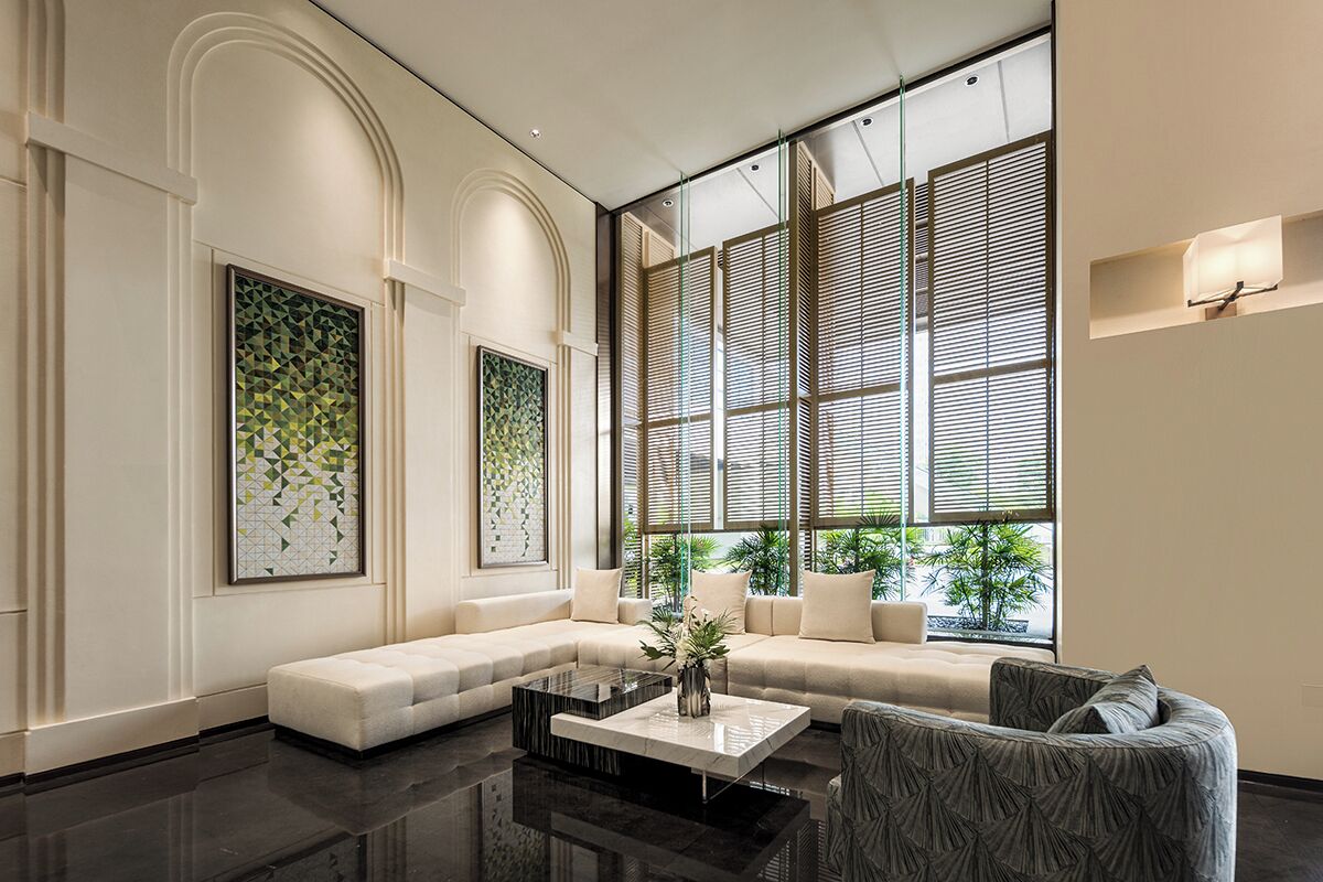 A modern interior with a sectional sofa, a coffee table, and large windows with blinds.