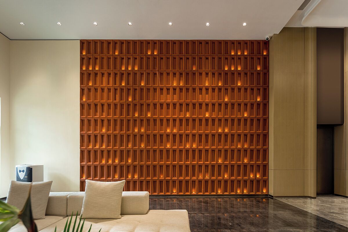 A modern interior with a patterned wall, a sofa, and a small table.