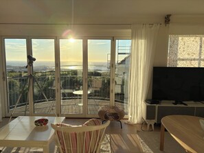 Een woonkamer met balkon, televisie en statief.