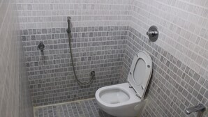 Un baño pequeño con inodoro, ducha y pared de azulejos.