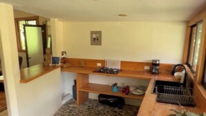 A kitchen with a stone floor, wooden counter, and a sink. - Unique 2 Story Dome (Rivas)