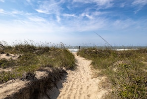 A sandy path leading to the beach with dunes on either side. - SeaEsta | Private Pool + 5 Min Walk to Beach (Emerald Isle)