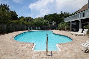 A swimming pool with a metal ladder, surrounded by a brick patio. - SeaEsta | Private Pool + 5 Min Walk to Beach (Emerald Isle)