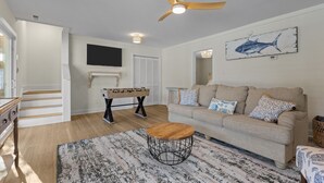 Un salon avec un canapé, une table basse et un ventilateur de plafond.