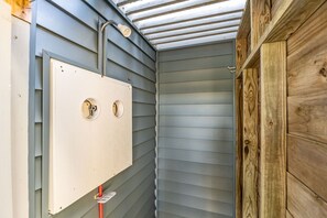 A room with a wooden door, a window with a metal frame, and a wall-mounted electrical box. - SeaEsta | Private Pool + 5 Min Walk to Beach (Emerald Isle)