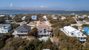 A coastal residential area with houses, a swimming pool, and a view of the sea. - SeaEsta | Private Pool + 5 Min Walk to Beach (Emerald Isle)