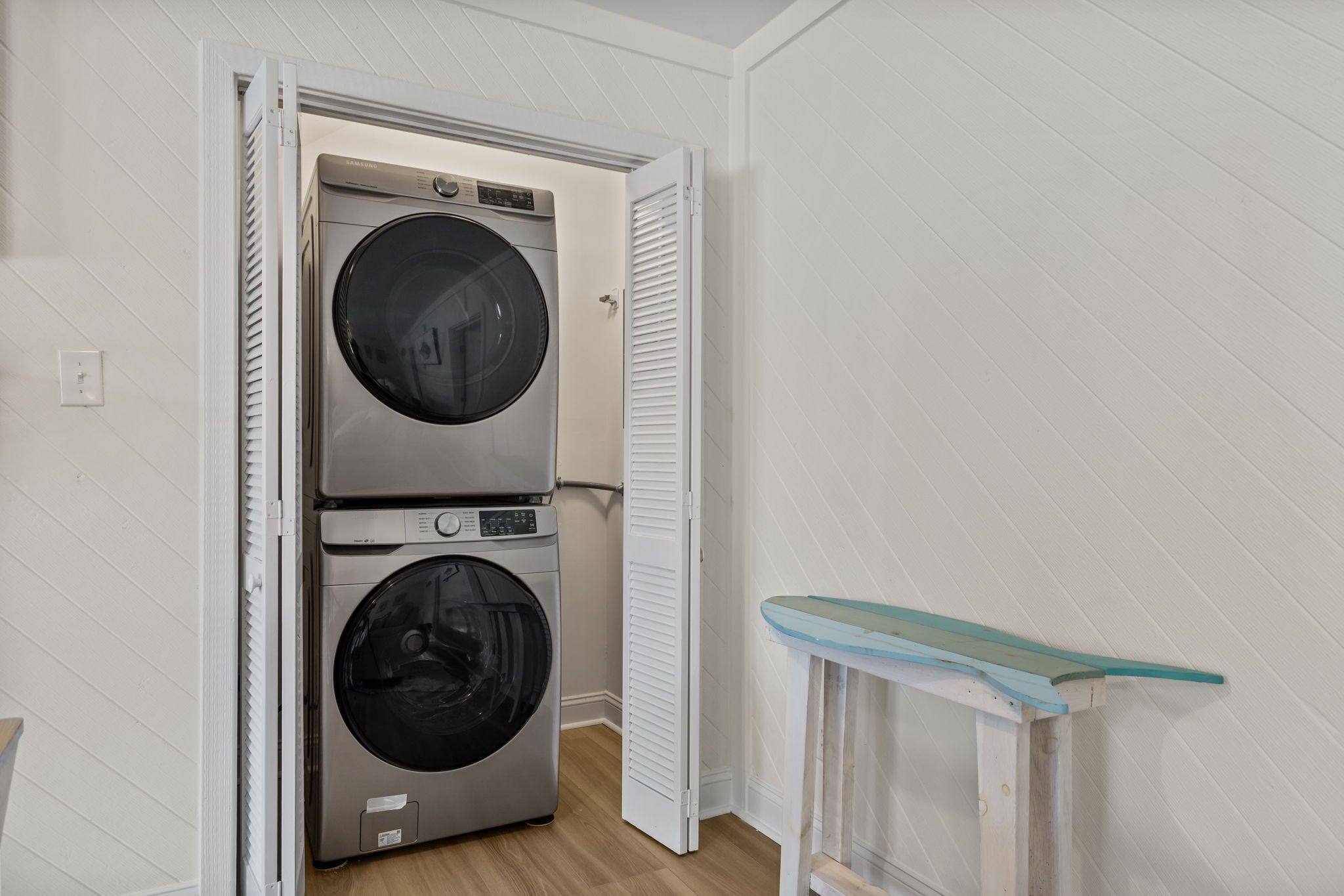 A laundry room with two stacked front-loading washers and dryers.