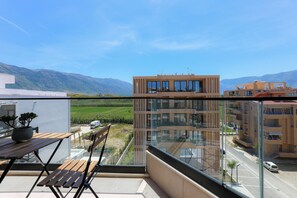 A modern apartment with a balcony overlooking a green landscape and mountains. - Seaside Serenity Palm Apartment (Orikum)
