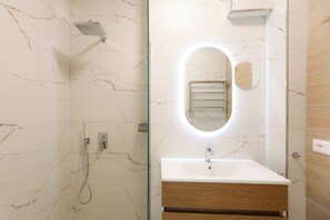 A bathroom with a shower, a sink, and a mirror. - Seaside Serenity Palm Apartment (Orikum)