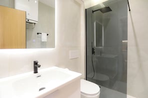 A modern bathroom with a white sink, a toilet, and a glass-enclosed shower area. - Modern Pool Side Studio Palm (Orikum)