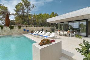 A modern outdoor pool area with lounge chairs and a dining table. - Casa de Romero 6 pax - Javea, Costa Blanca (Javea)