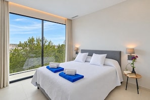 A hotel room with a large bed, two bedside lamps, a nightstand, and a view of the outdoors. - Casa de Romero 6 pax - Javea, Costa Blanca (Javea)
