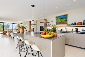 A modern kitchen with a central island, bar stools, and a large window offering a view. - Casa de Romero 6 pax - Javea, Costa Blanca (Javea)