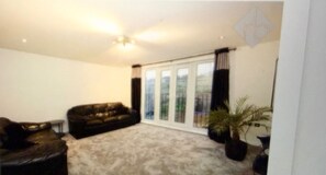 A living room with a sofa, a coffee table, and a potted plant. - Rent my Sheffield City Home (Sheffield)