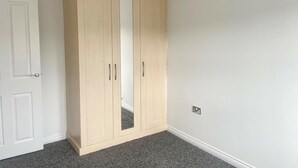 A room with a large wardrobe, a door, and a light fixture. - Rent my Sheffield City Home (Sheffield)