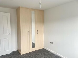 A room with a large wardrobe, a door, and a light fixture. - Rent my Sheffield City Home (Sheffield)