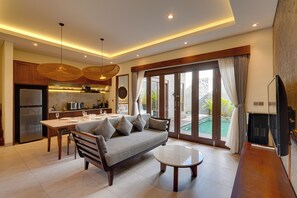 Una sala de estar moderna con sofá, mesa de centro y comedor.