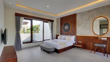 A modern bedroom with a large bed, a wooden dresser, a vanity with a mirror, and a television on the wall.