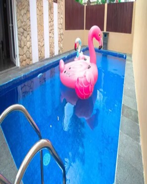 Una piscina con un flotador de flamenco rosa.