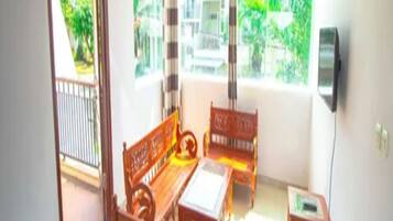 A room with a wooden bench, a table, and a TV on the wall.