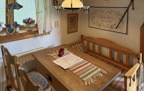 A cozy dining area with a wooden table, benches, and a patterned rug. - 1 bedroom lovely home in Leksand (Leksand)