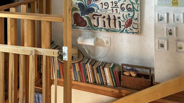 Een houten boekenplank met boeken en een klein houten doosje.