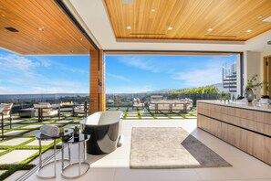A modern kitchen with a large island and a view of the city. - Somera Masterpiece (Los Angeles)